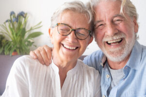 Senior couple smiling together after addressing dental problems before retirement