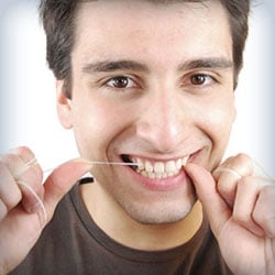 man showing how to floss teeth