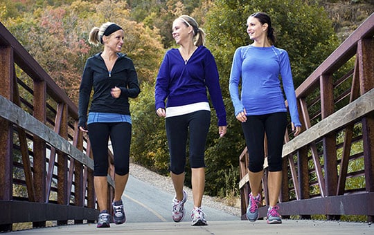 group of 3 women walk-exercising